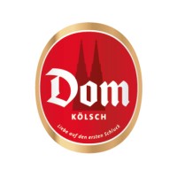 Rundes Logo mit rotem Hintergrund, weißer Text und einer Silhouette von zwei Türmen.